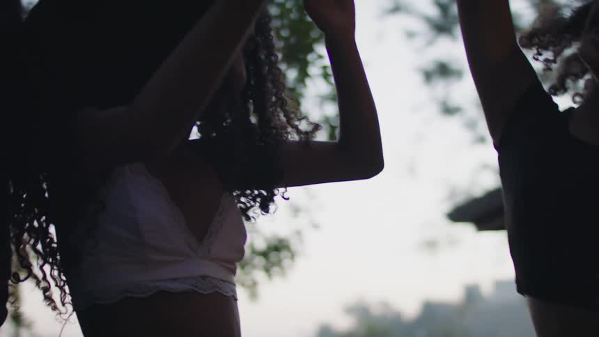 Three girls are outdoors and dancing