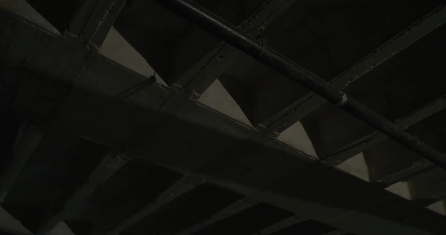 A laser flashes off of beams in a ceiling