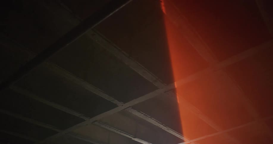 A red light is shining on the ceiling of a building