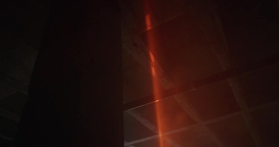 A red laser shining on the ceiling of a dark room