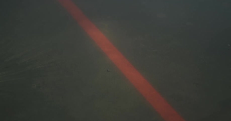 Smoke moves over an orange line on the concrete