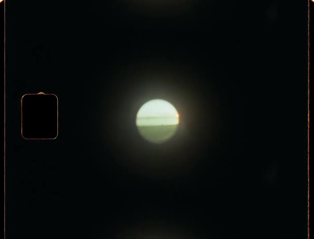 Looking through the visor of a coin operated beach binocular at sunset caught on vintage film