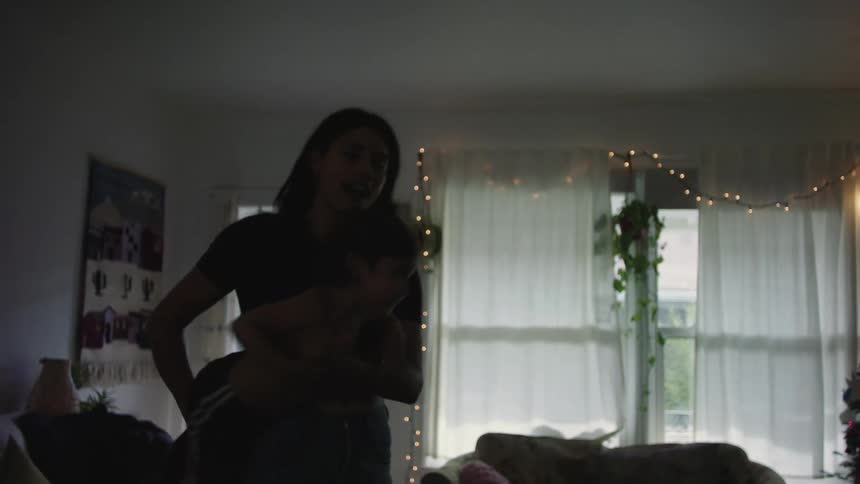 A woman swings her child around the room