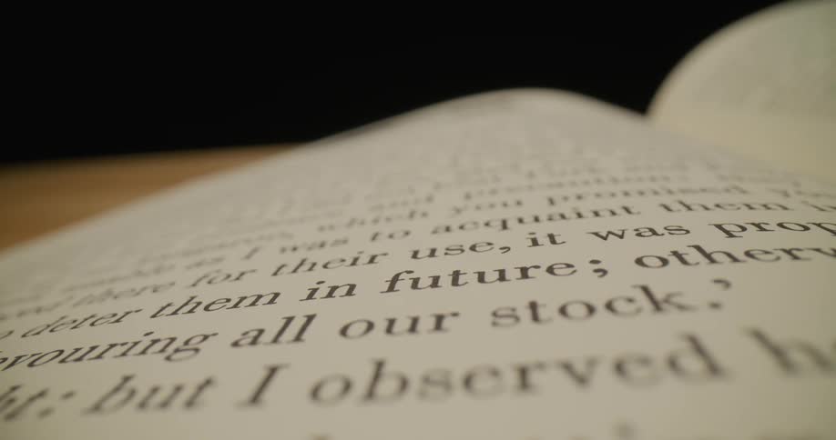 Large open books sits on wooden surface
