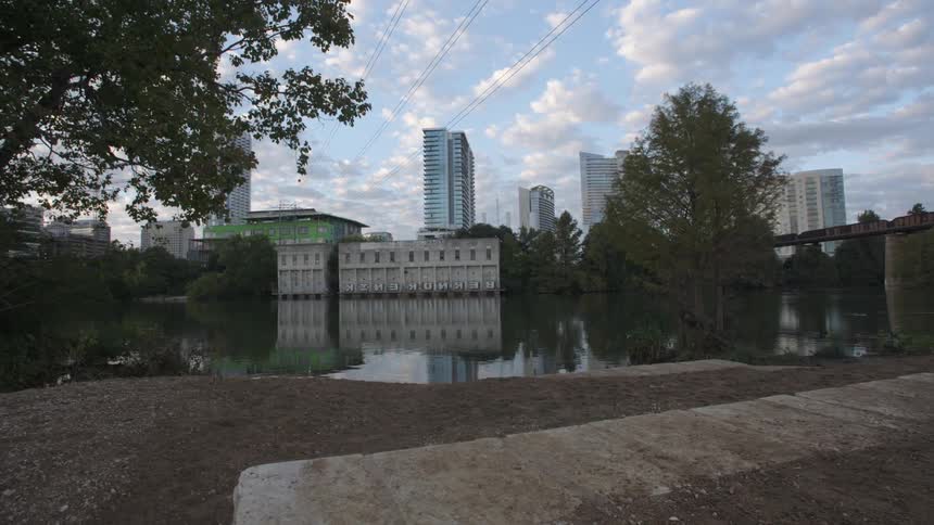 A city sits beyond a small body of water on a cloudy day