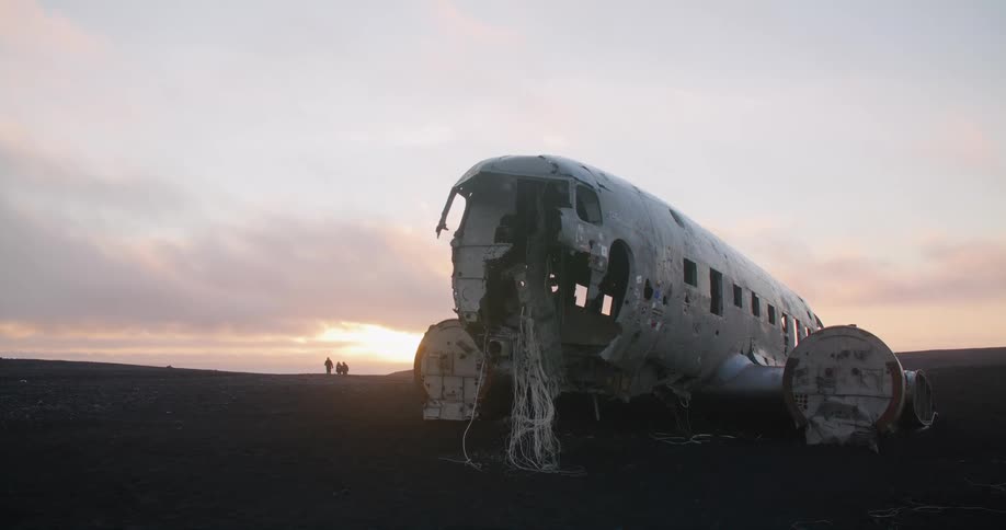An airplane is parked on the ground and is broken down
