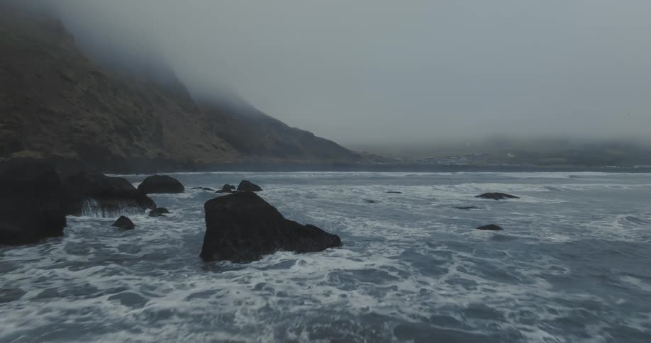 Waves crash into the rocks on a mountainous coast