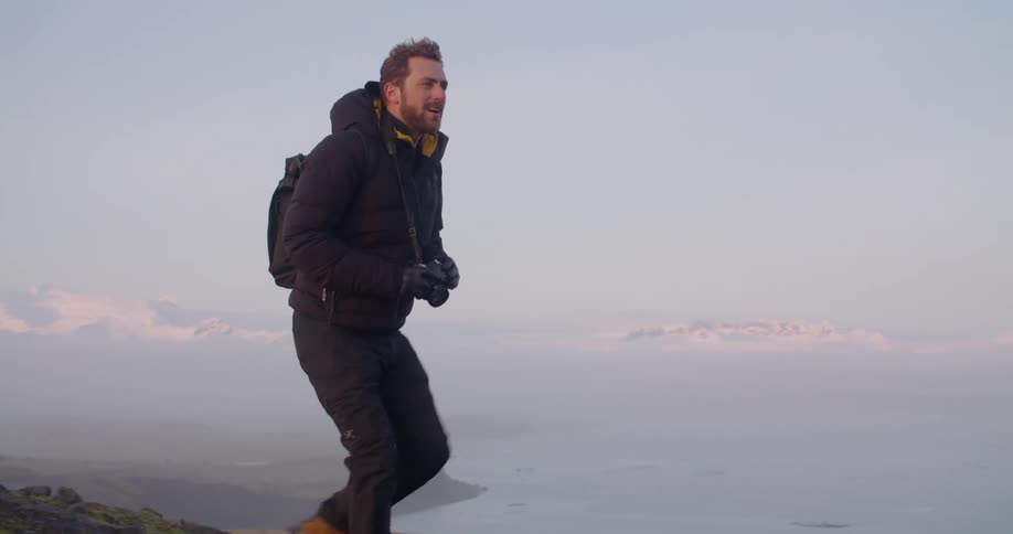 A man hiking in nature with a camera on a cold winter morning