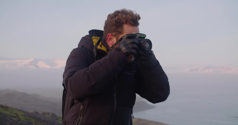 A man is taking photos by the shore