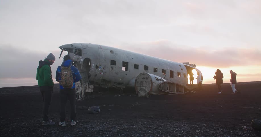 People stand at an airplane crash site and look at the wreckage
