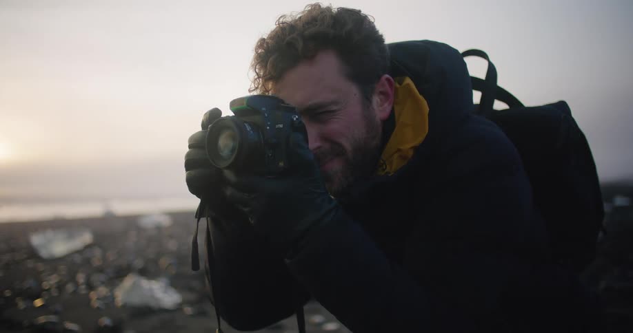A man is on the coast of a beach and photographing it