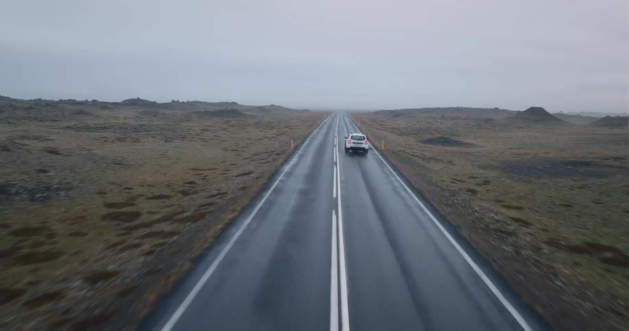 Cars traveling on a rural road on a foggy cloudy day