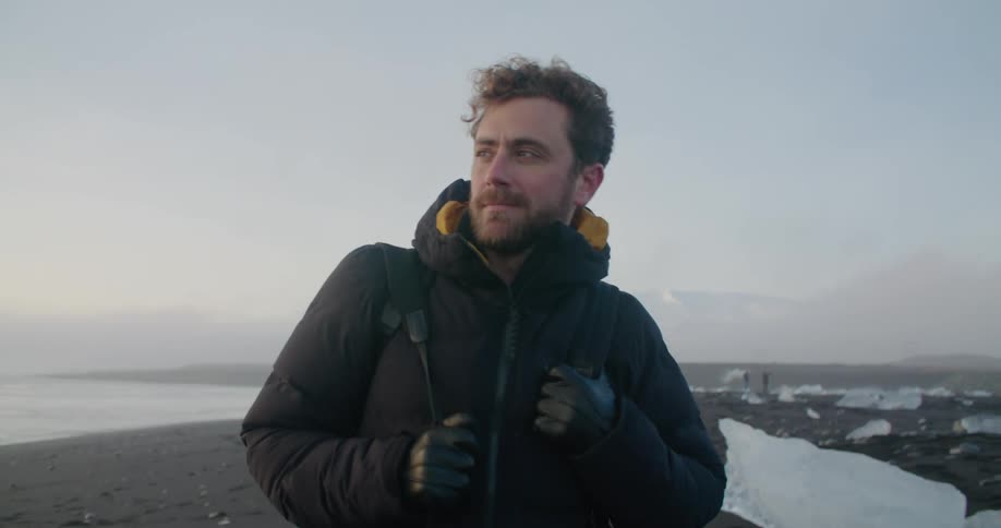 A man is walking on the beach in winter