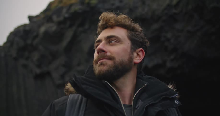 A man is smiling outdoors in winter