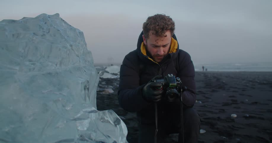 A man is photographing the beach landscape at dusk