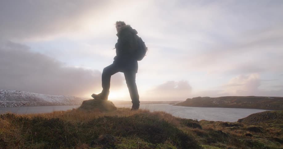 Young man standing near the reynisfjara black sand beach at sunset