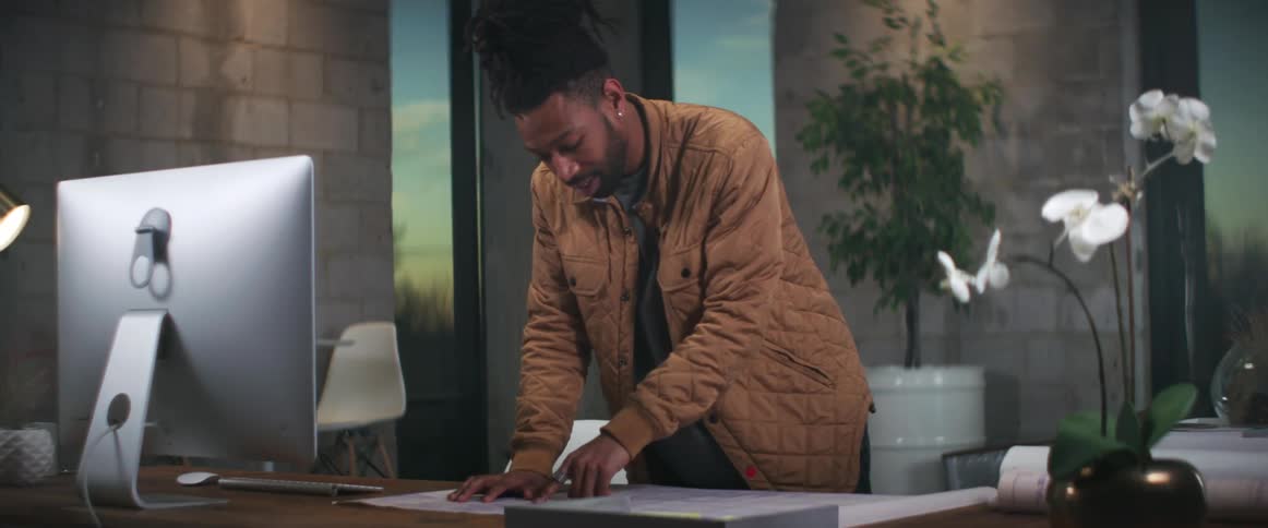 A man is in a office with a laptop
