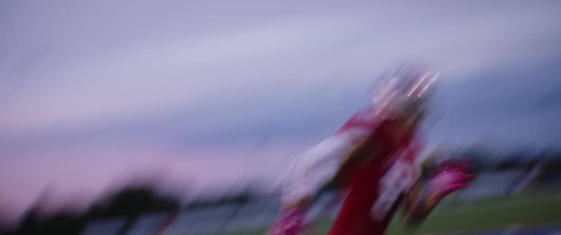 A football player catches a ball and runs as a referee watches