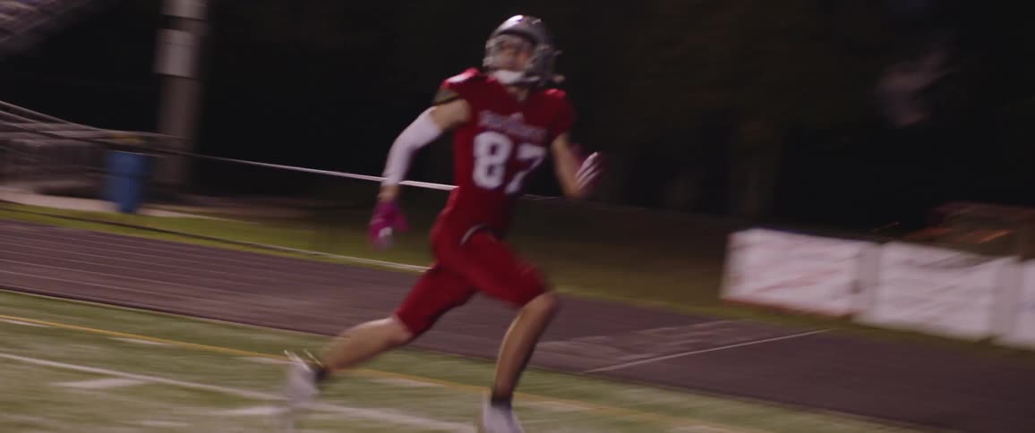 A football player runs and catches the ball