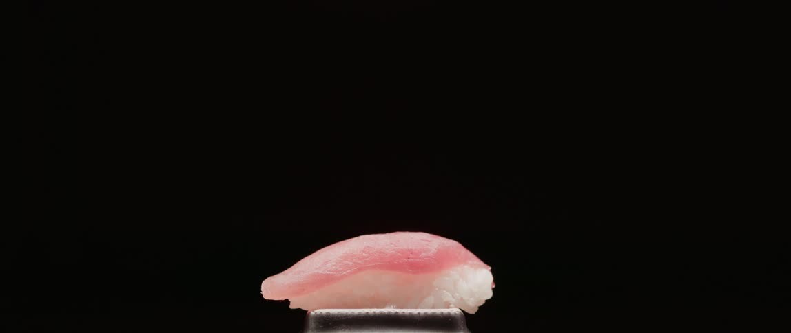 Person places and picks up sushi roll
