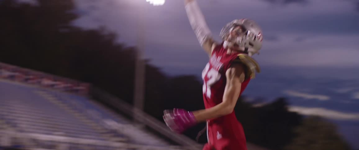 A football player runs and catches a football during practice