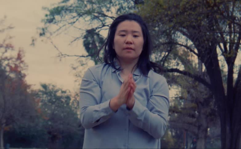 A woman is dancing an expressive dance outdoors