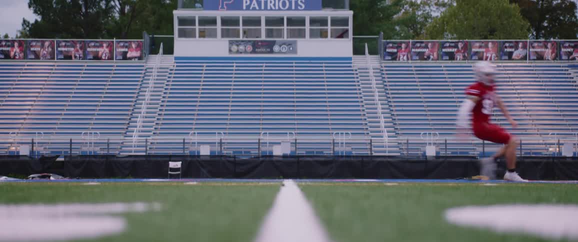 A football player in full gear is running back and forth doing drills on a field