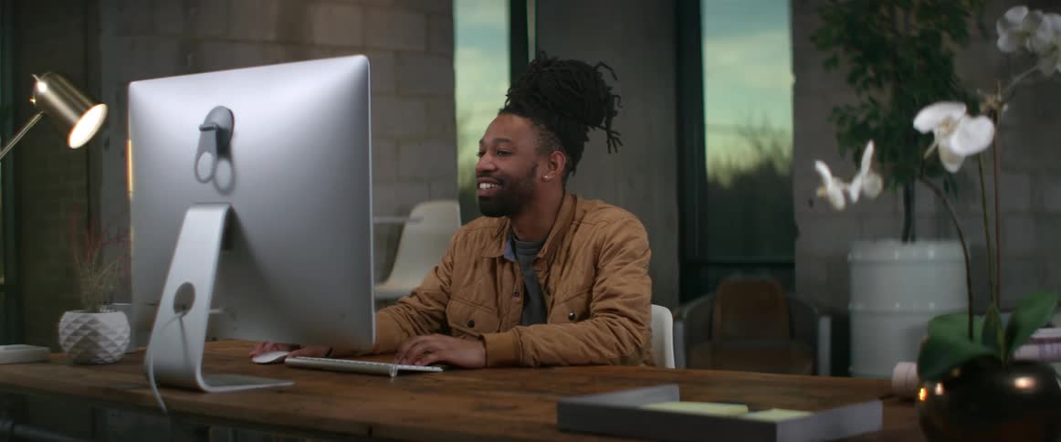 A man smiles as he works at his desk