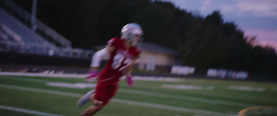 A football player runs and catches the ball