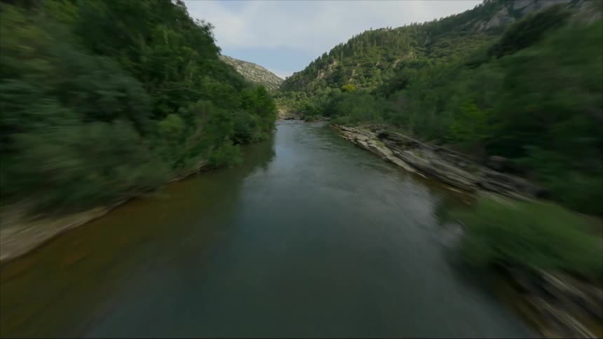 An aerial view of a river flowing through vegetation in nature