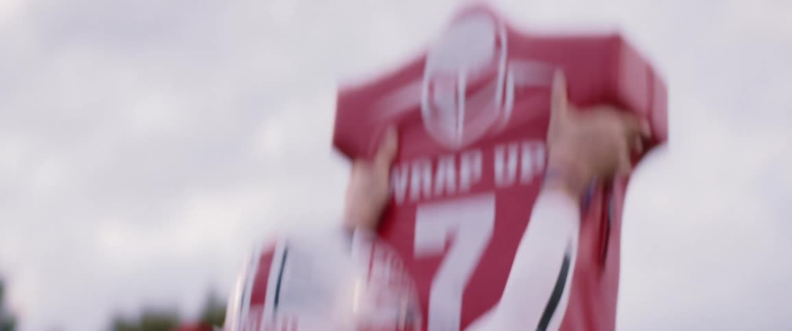Football player practices with tackling dummy on field