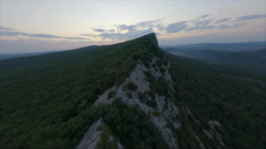 Thick bushes cover the sides and peak of a mountain