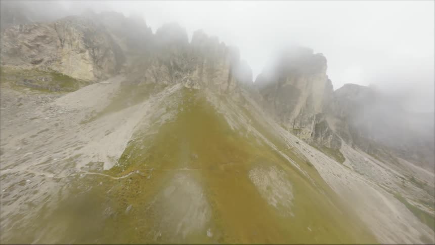 An aerial view of tall rocky cliffs in the wilderness on a rainy day