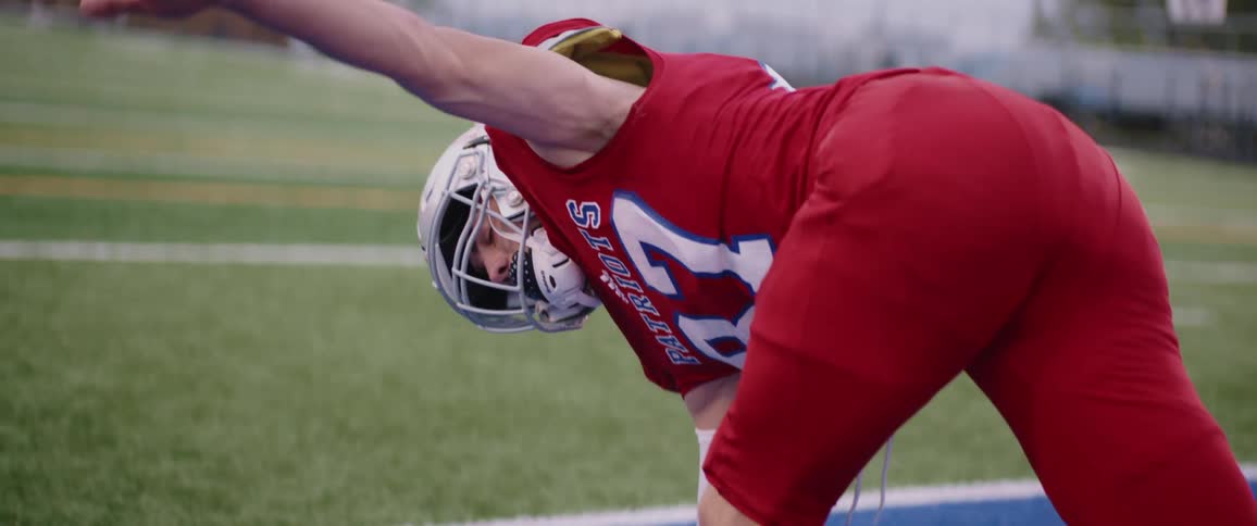 Male american football player in red jersey warms up in american football stadium