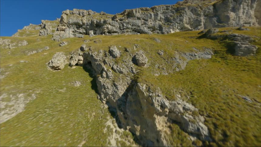 A grassy hill with rocks on it