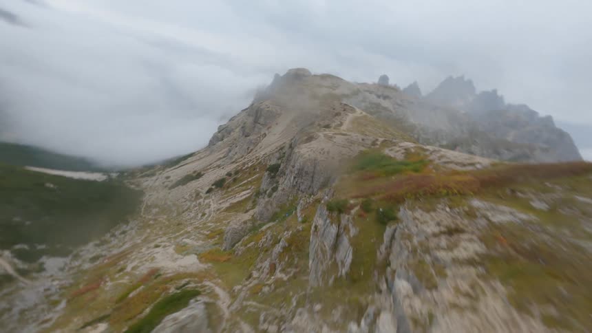 A gravel road leads to a remote home at the summit of a canyon