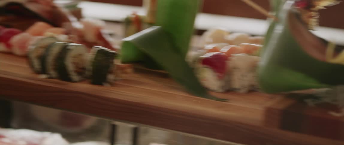 Sushi rolls occupy small wooden platform