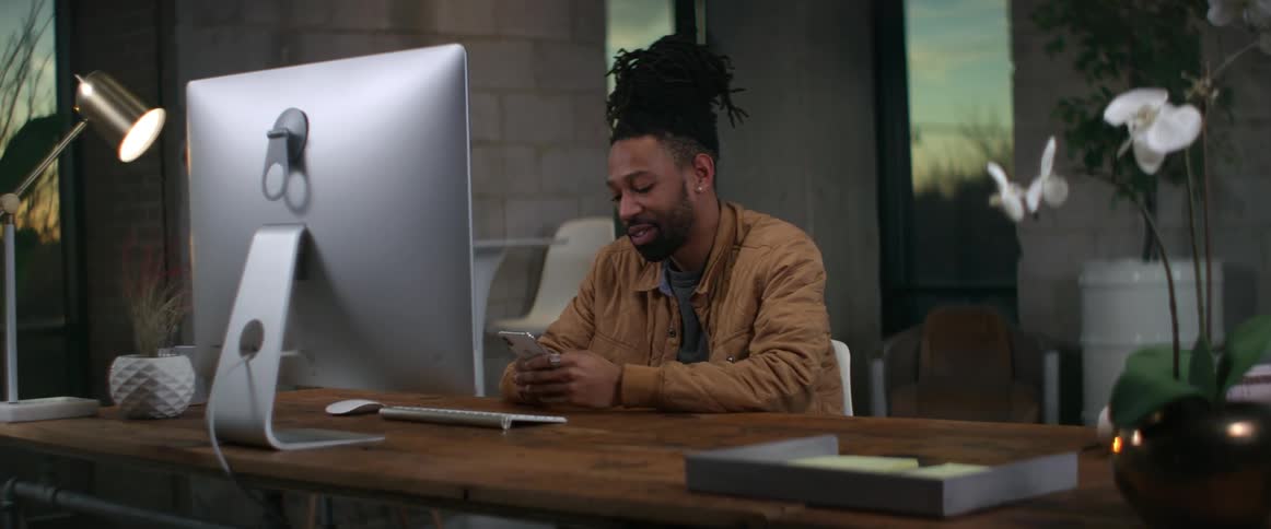 A man is using his cell phone in his office