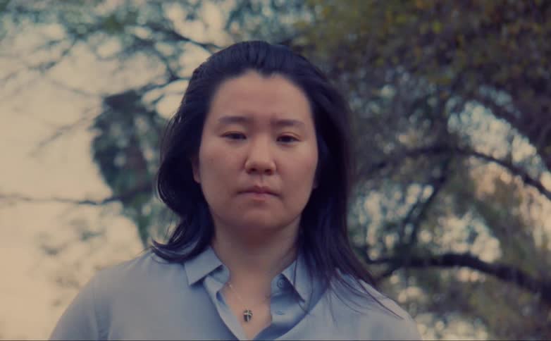 A person is standing outdoors next to a tree