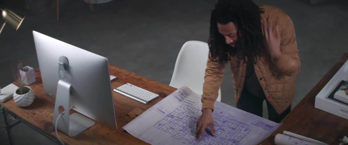 A man rolls out and reads a blueprint