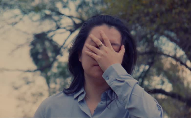 A woman yawns and wipes her face