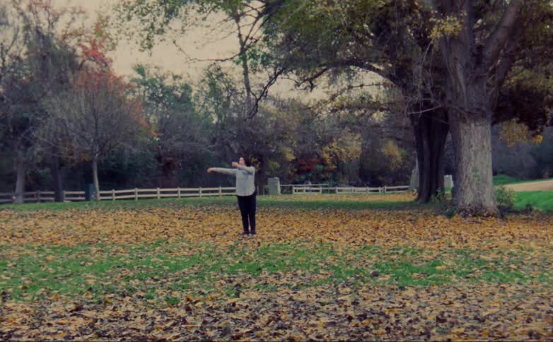 A woman does a modern dance in a public park