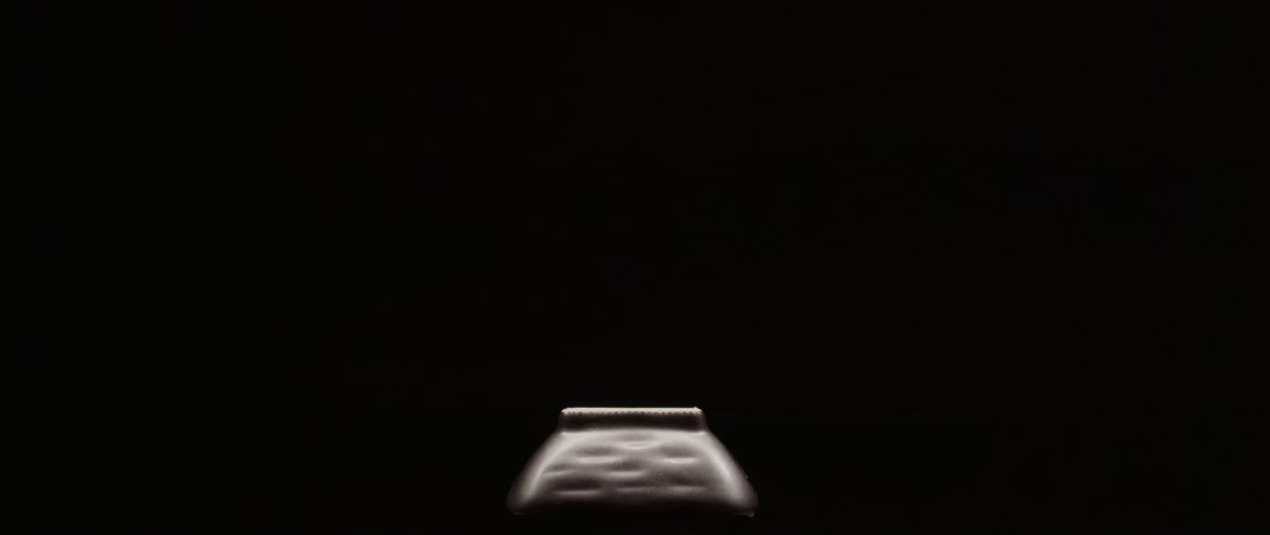 A person picks up a piece of sushi with chopsticks