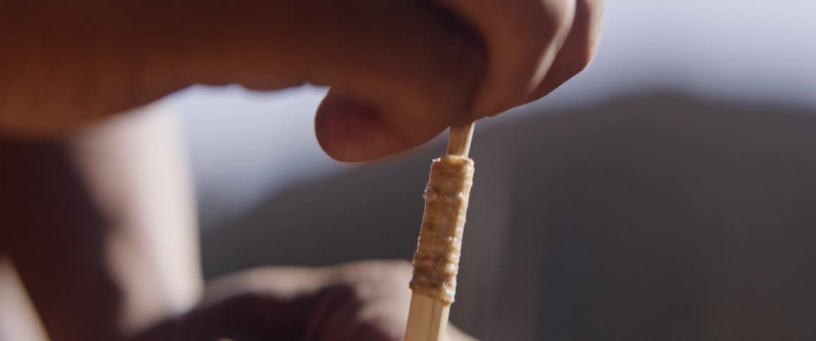 Person attaches section with arrow head into bottom section of arrow
