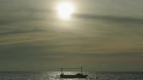 A boat floats on a body of water during the day