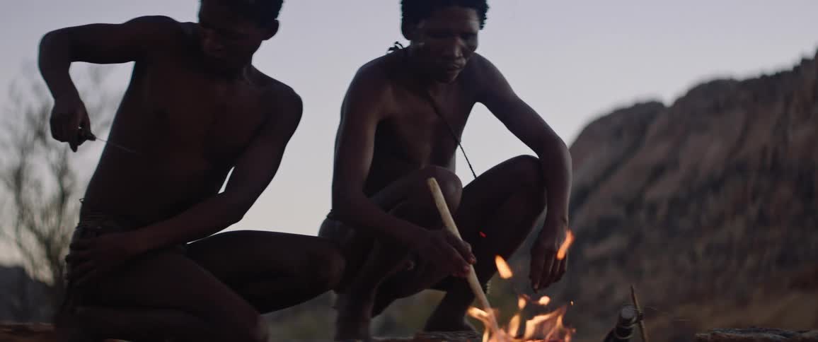 Two men build a fire