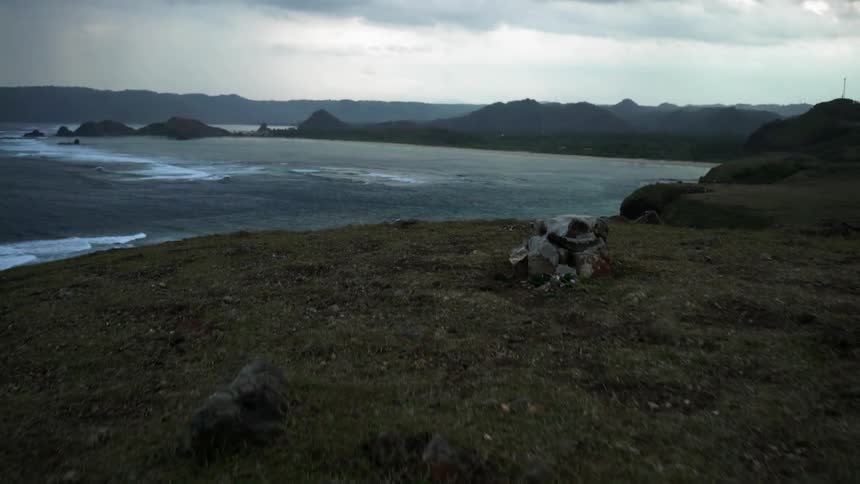 Moving up a grass covered hill to reveal a shore