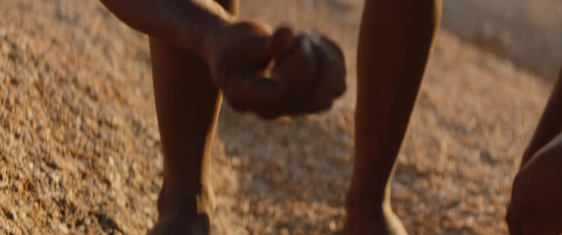 Tribal hunters dressed in loincloths tracking prey