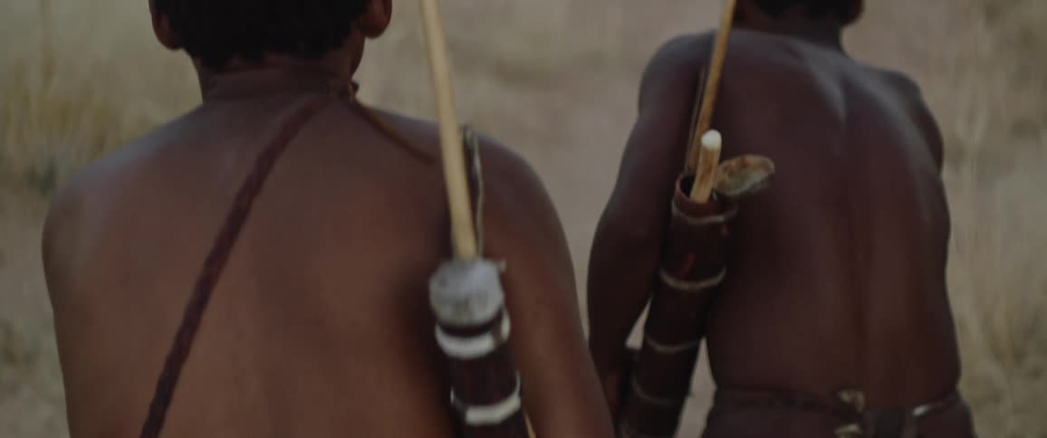 Tribal men with bows track down prey to hunt