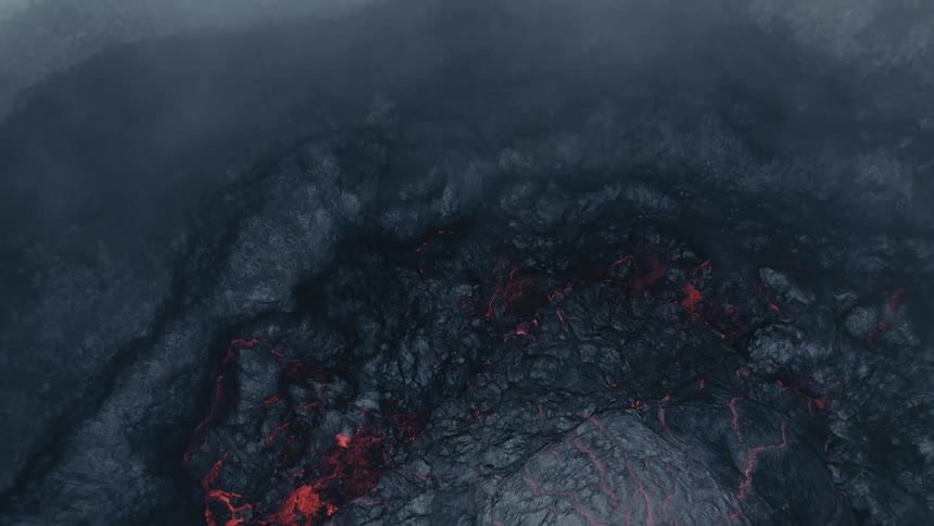 Smoke fills the air as lava starts to flow from an erupting volcano